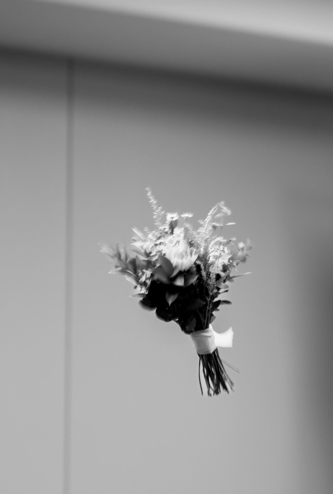 Bridal bouquet tossed into the air, black and white