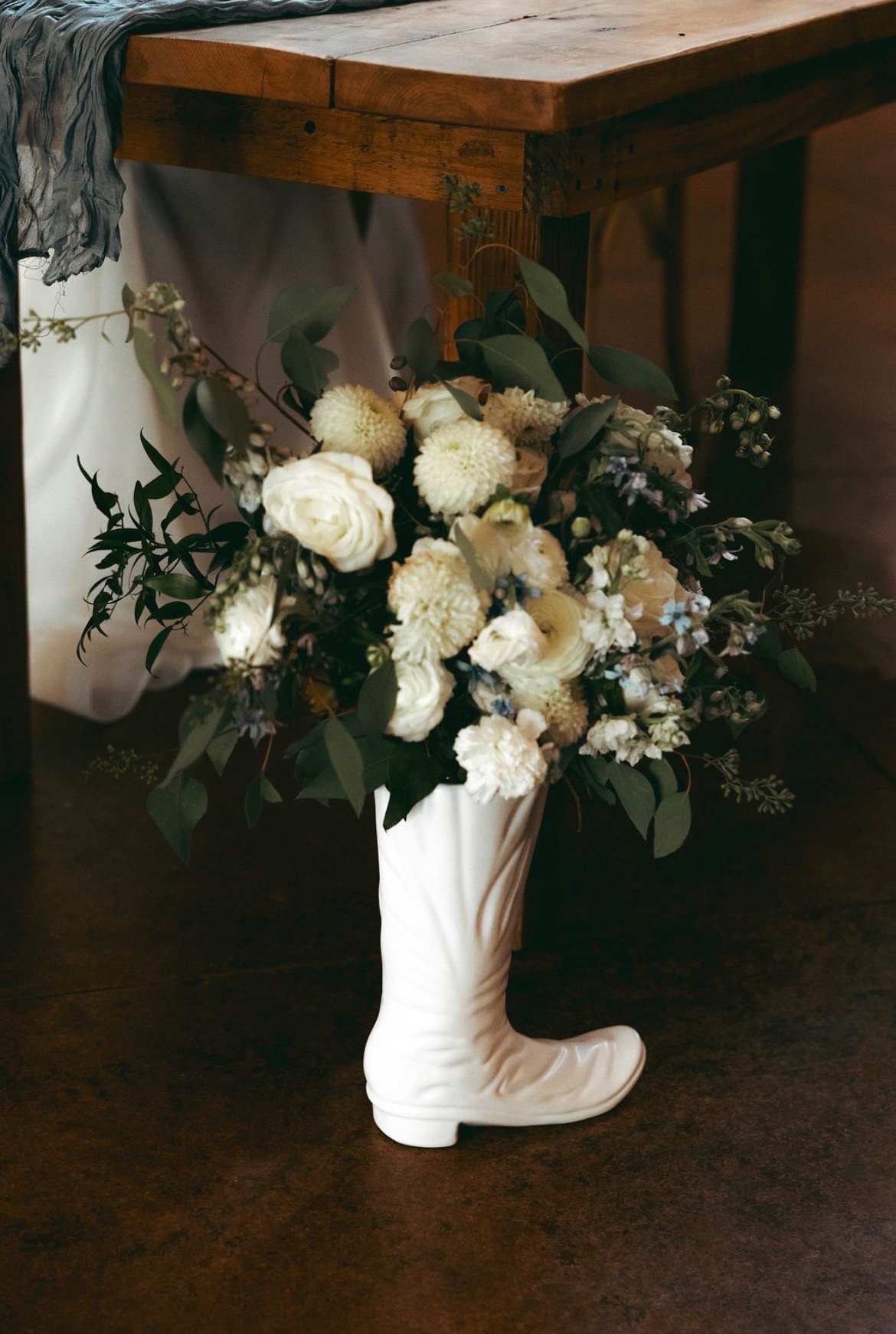 Bride in motion down a wooden hallway with her bouquet, black and white