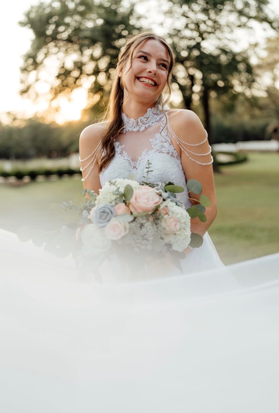 Bride laughing in golden hour light with her bouquet