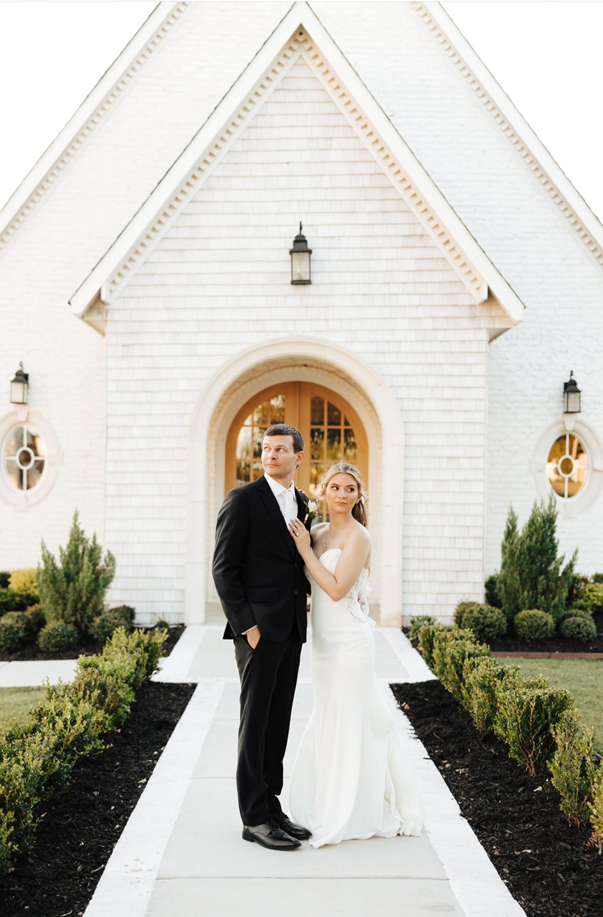Bride and groom standing together outside a white Dallas-area chapel