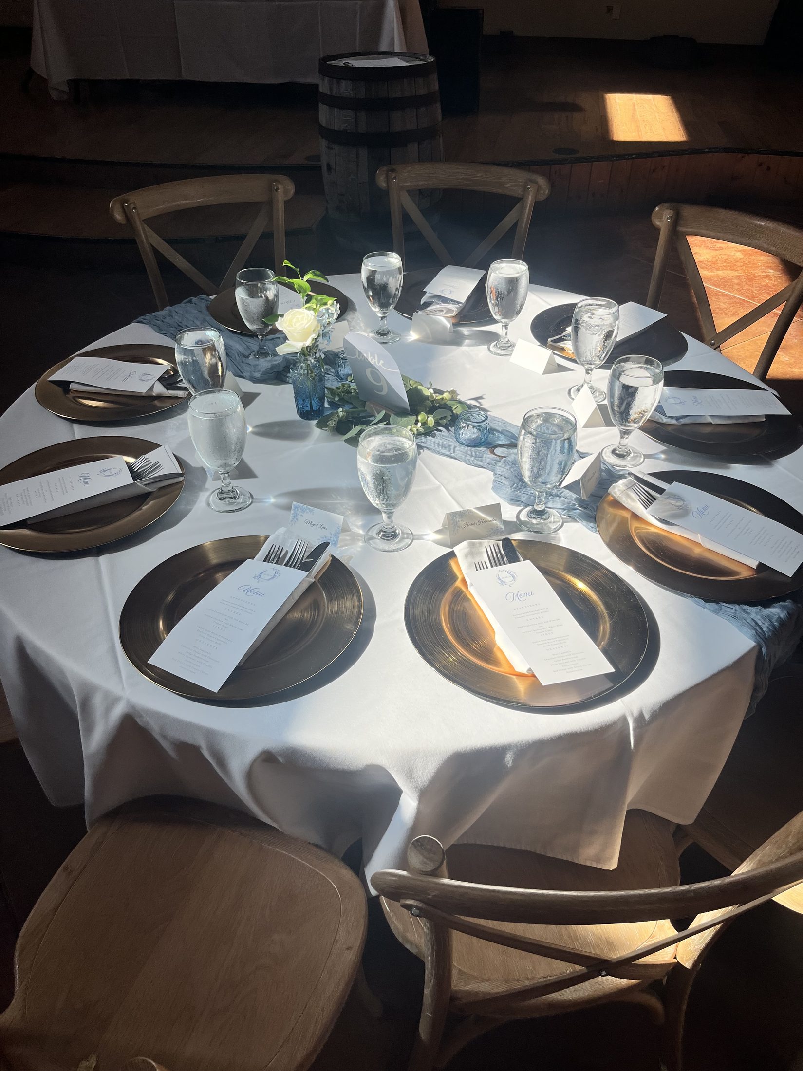 Sunlit reception table with gold chargers and menu cards