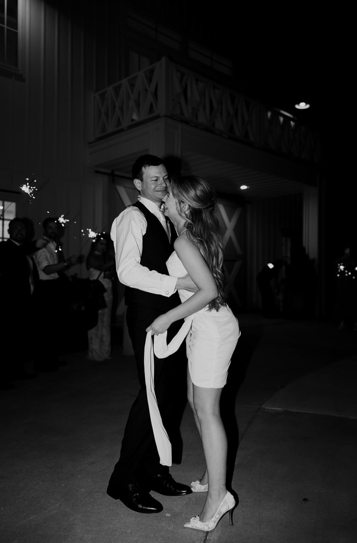 Bride and groom dancing during their sparkler exit, black and white